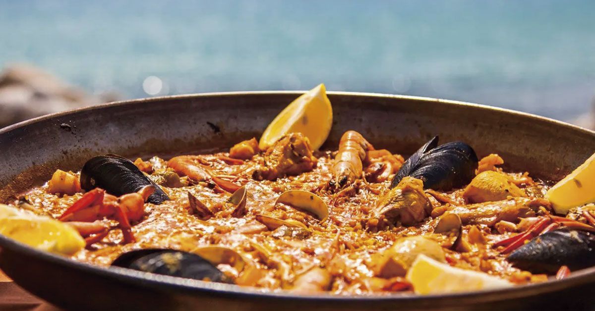Traditional paella with the sea of Ibiza in the background